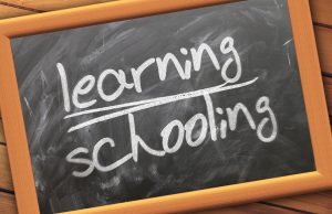 Blackboard slate with 'Learning, Schooling' written on it